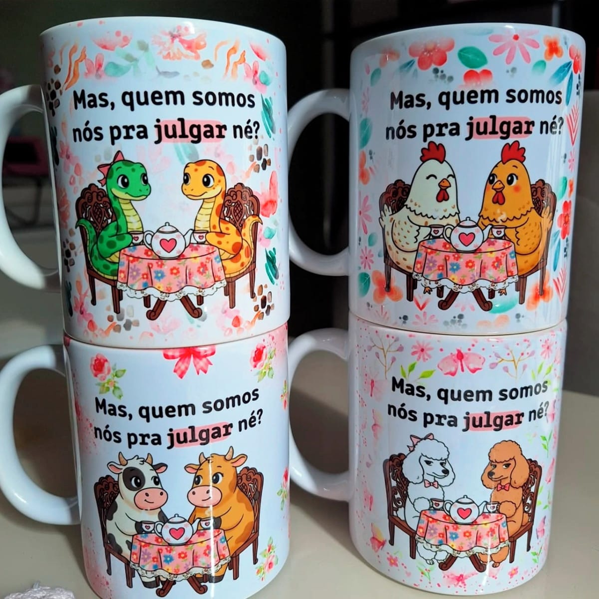 6 Artes Digitais para Sublimação em Canecas Tema Amizade 1 Quatro canecas brancas exibindo designs de animais em pares tomando chá.