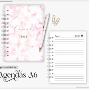 Agenda espiral com capa marmorizada rosa, caneta branca, clipes e página interna pautada.