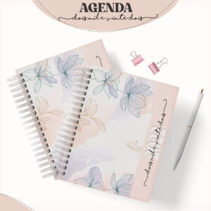 Duas agendas decoradas com flores, caneta branca e clipes rosa sobre fundo claro.
