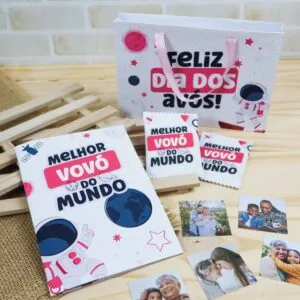 Sacola de presente branca com tema espacial e fotos impressas espalhadas sobre a mesa