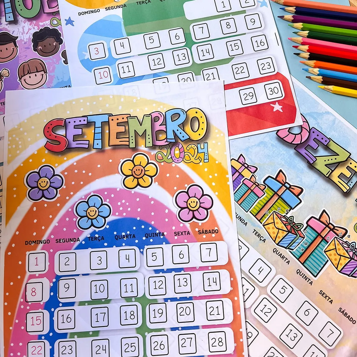 Arquivo Digital Calendário Fofo Infantil 2024 em Pdf 4 Várias folhas de calendários coloridos com desenhos infantis e lápis de cor dispostos.