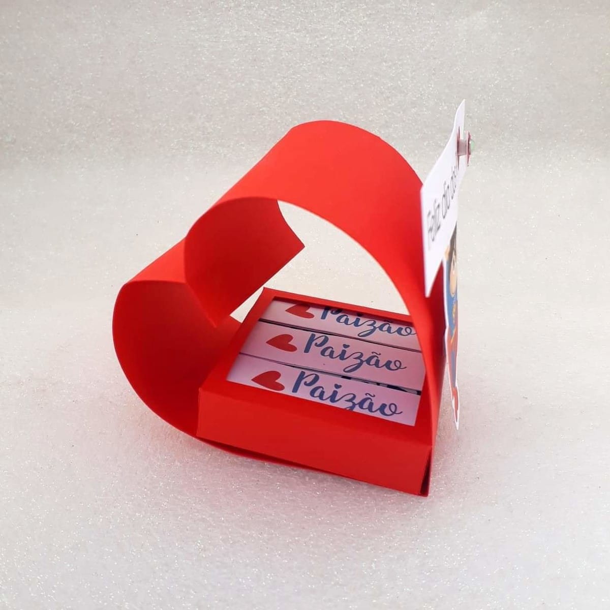 Arquivo Studio Dia dos Pais coração com escrita Paizão 1 Caixa vermelha em formato de coração contendo pequenos chocolates personalizados com texto.