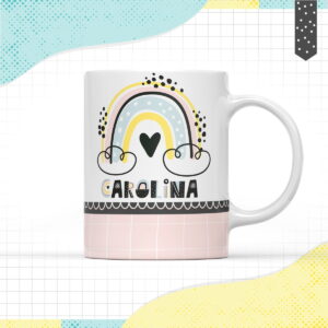 Caneca branca com design infantil de arco-íris pastel, nuvens e um coração. Texto abaixo.