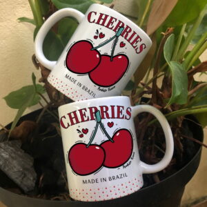 Duas canecas brancas com estampa de cerejas e texto 'CHERRIES' sobre planta.