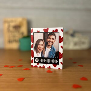 Design de arte digital com foto de casal, código Spotify e corações vermelhos.