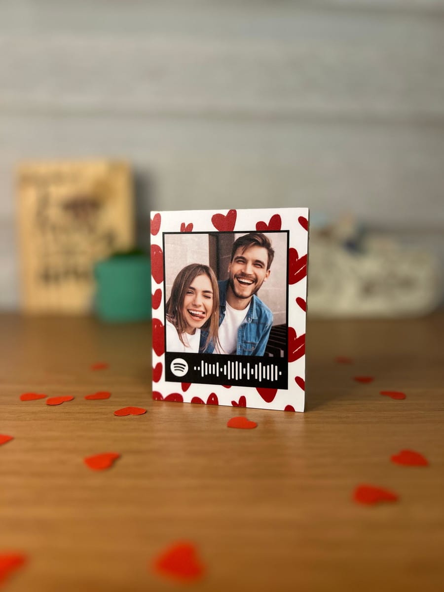 Arte Polaroid Namorados Canva com QR Code Spotify 1 Design de arte digital com foto de casal, código Spotify e corações vermelhos.