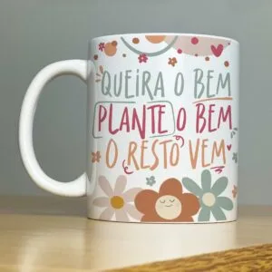 Caneca branca com estampa colorida contendo frase motivacional e ilustrações de flores.