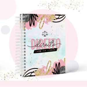 Caderno espiral com capa decorada em tons pastéis, glitter dourado e símbolos jurídicos pretos.