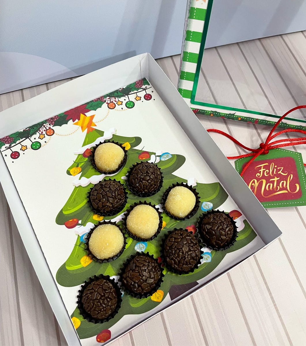 Caixa Árvore de Natal para Doces em PDF e Studio 1 Caixa aberta com doces em formato de árvore de natal sobre fundo listrado.