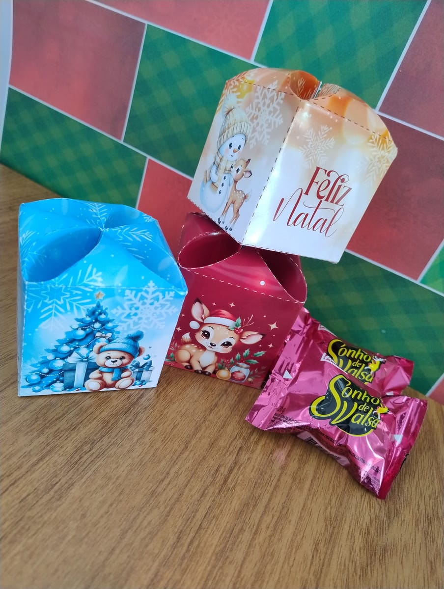 Caixinha de Bombom Natal PNG e PDF para Lembrancinhas 2 Templates de caixas natalinas e doces em superfície de madeira com fundo festivo.
