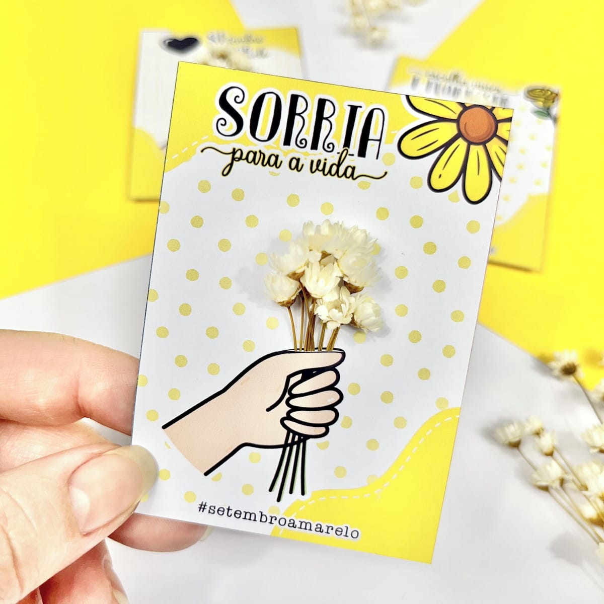 Card Setembro Amarelo PNG e PDF para Imprimir 4 Arte digital amarela com frase 'Sorria para a vida', ilustração de mão e flores.