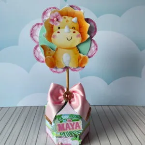 Topo de bolo com desenho de dinossauro amarelo e laço rosa decorativo