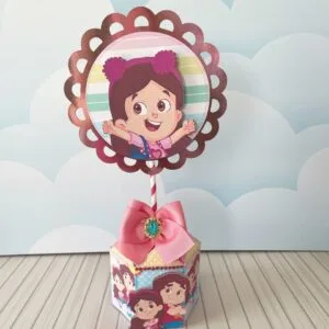Centro de Mesa Maria Clara e Jp - Arquivo Digital 29 Decoração de mesa personalizada com ilustração de menina em estilo cartoon sobre caixa hexagonal.
