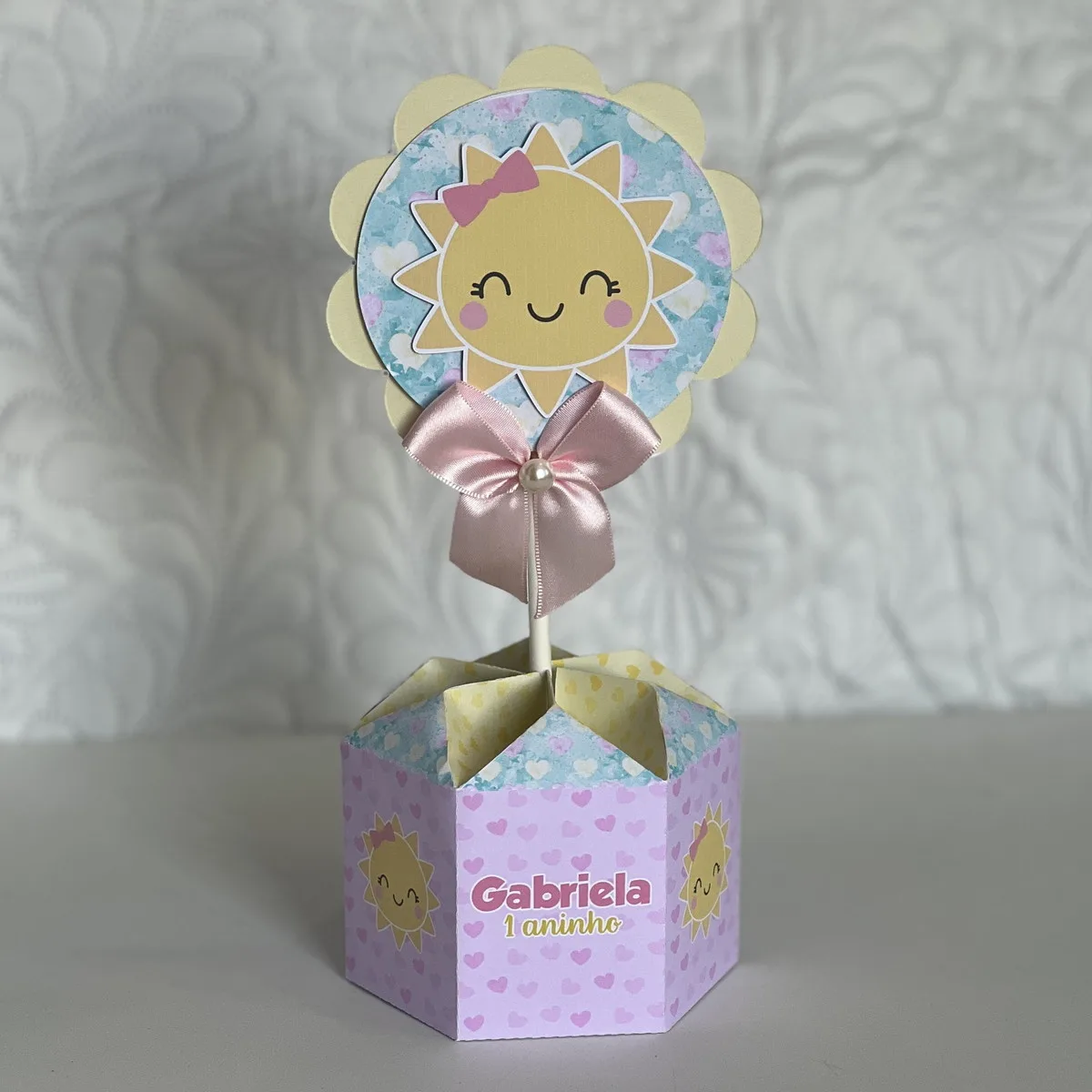Centro de Mesa Sunshine Menina - Arquivo Digital 1 Decoração de mesa em papelaria personalizada com tema de sol sorridente e cores pastéis.