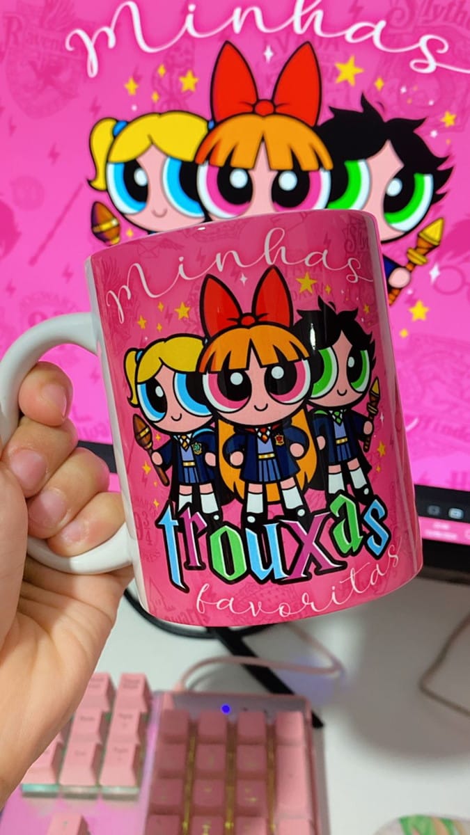 Estampa Meninas Super Poderosas Bruxinhas para Caneca PNG 4 Mão segura caneca rosa com ilustração de personagens e texto divertido, fundo digital.