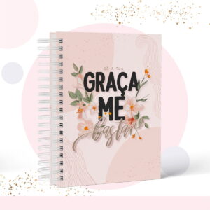 Caderno espiral com capa rosa decorada com flores e inscrições pretas e douradas.