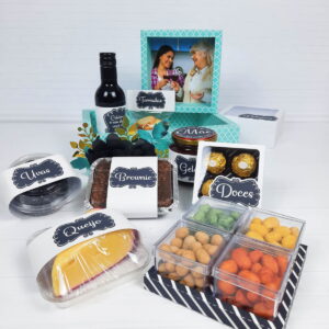 Itens visíveis em um conjunto de presentes, incluindo alimentos, uma garrafa e uma foto.