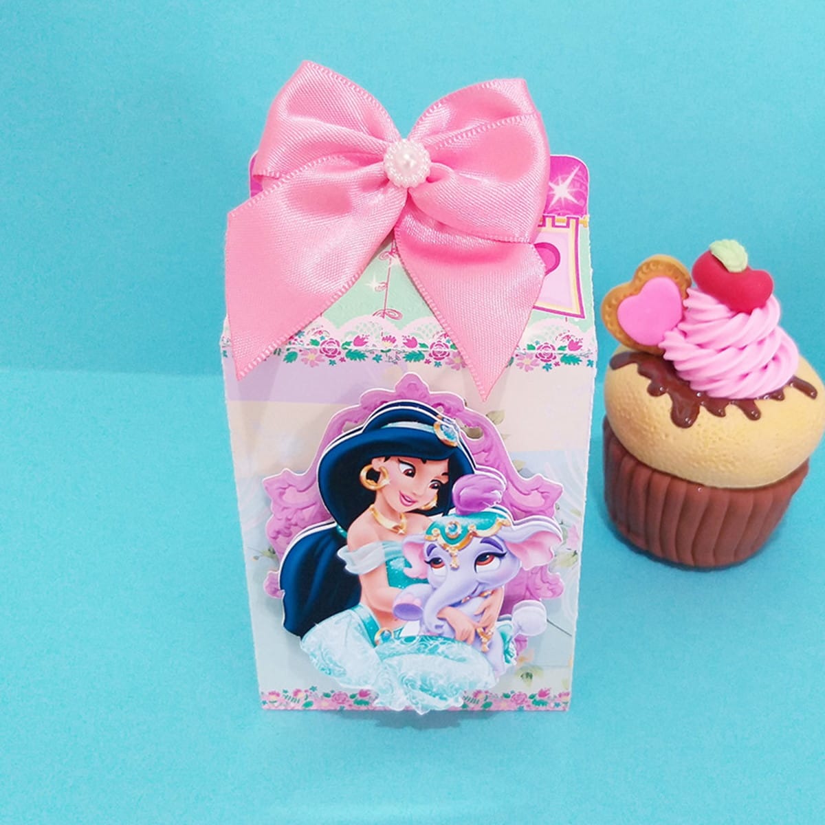 Kit digital festa Princesas Disney com moldes de corte 3 Caixa decorada com personagem feminina e elefante bebê, ao lado de miniatura de cupcake.