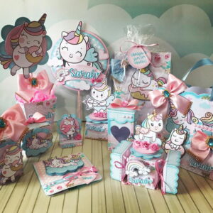 Designs de festa tema unicórnio com caixas, sacolas e decorações coloridas.