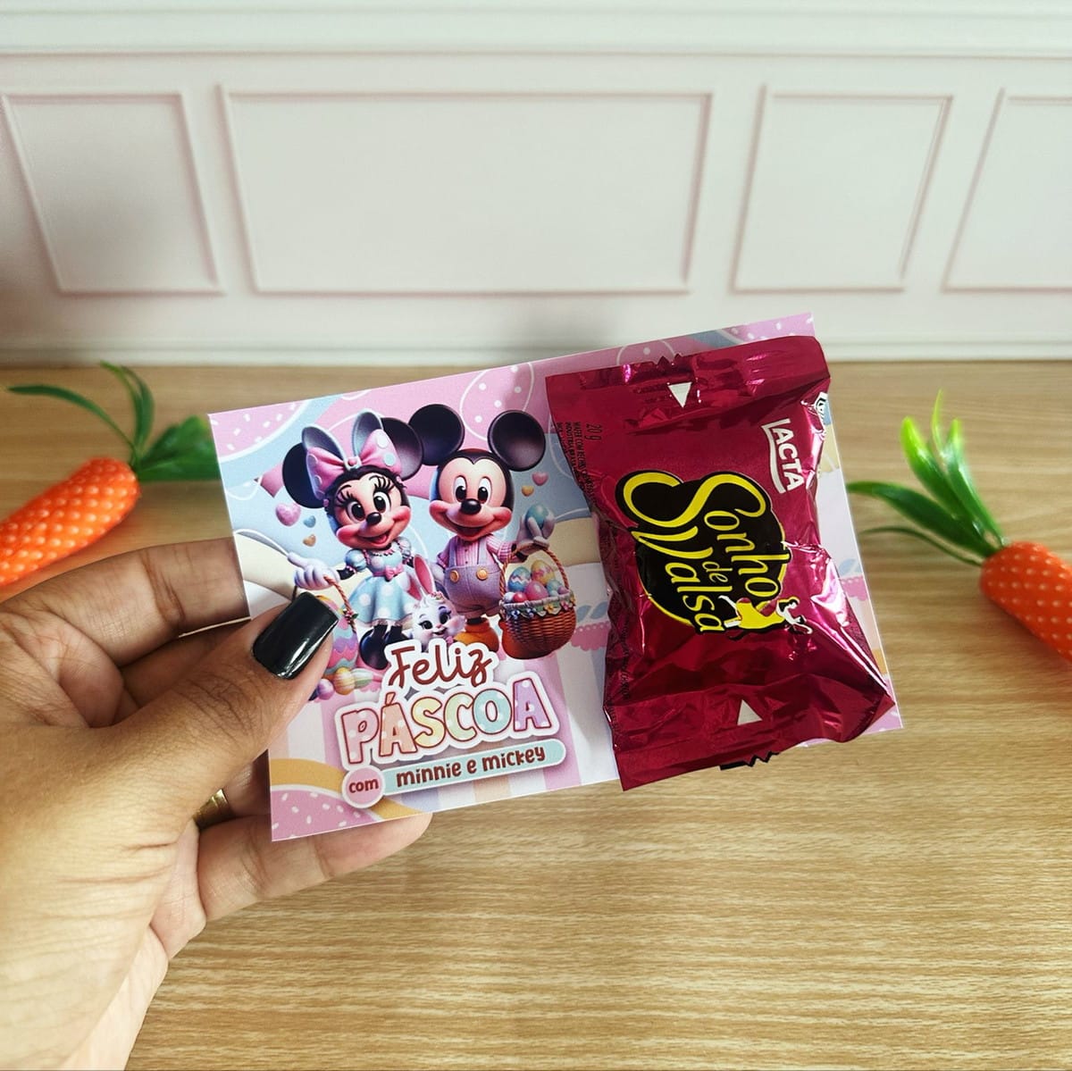 Kit Digital Mimos de Páscoa Minnie e Mickey 3 Mão segura cartão de Páscoa com figuras de desenho e um bombom.