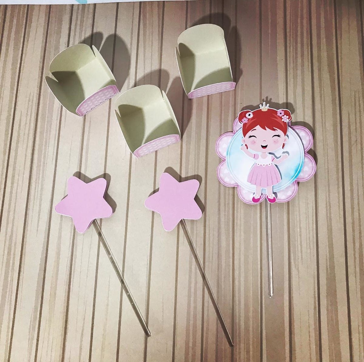 Kit É Só um Bolinho Menina Arquivo Digital com Studio e PDF 5 Decorações de festa com três wrappers, duas estrelas rosa e um topper de fada.