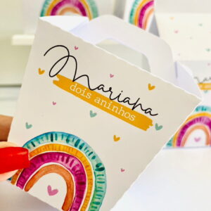 Design digital de caixa de lembrancinha com arco-íris, corações e texto de idade.