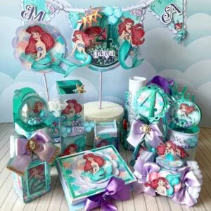 Conjunto de decorações de festa com tema de sereia, incluindo caixas e toppers com desenhos.