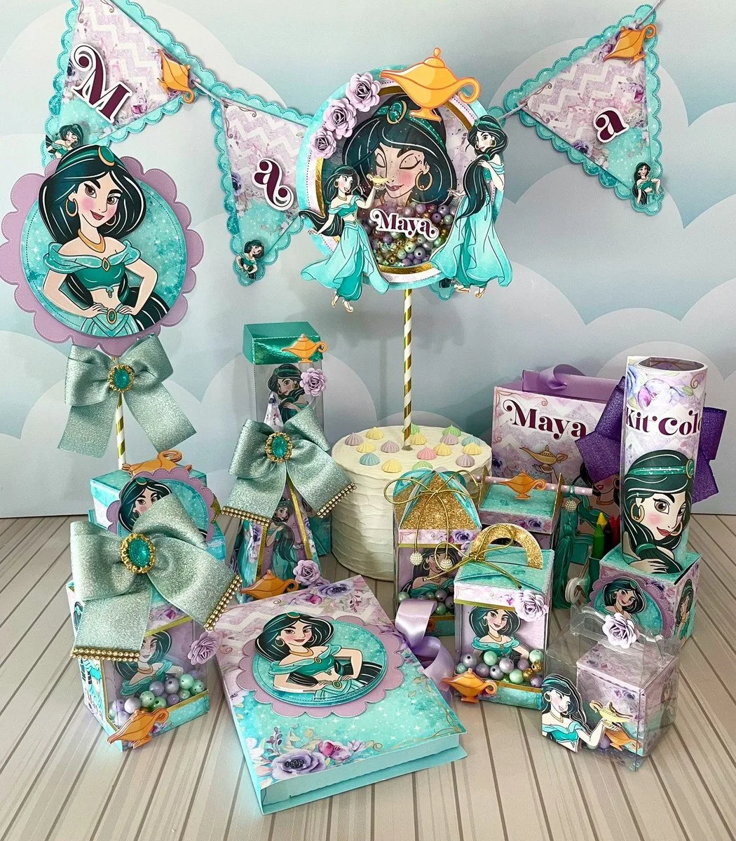 Conjunto de decorações de festa temática com cores verde e roxa em uma mesa.