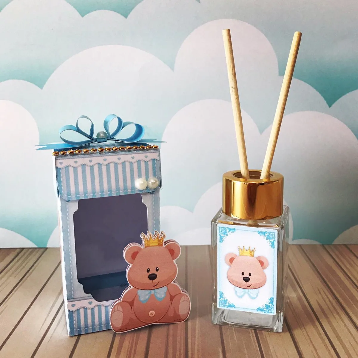 Caixa decorada em tons de azul e frasco de aromatizador com varetas e ursinho.