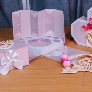 Kit Mães Rosa - Arquivo Digital 7 Caixas de presente decoradas em tons de rosa com laços e flores em uma mesa.