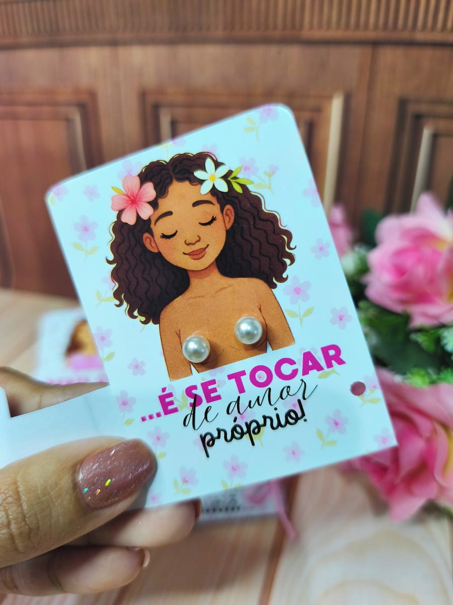 Kit Mimos Outubro Rosa 2025 para Lembrancinhas 1 Cartão branco com ilustração de mulher e brincos de pérola, segurado por uma mão.