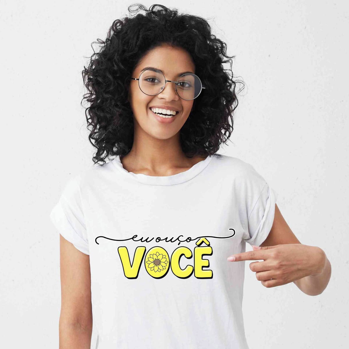 Kit Setembro Amarelo Digital com PNG para Imprimir 5 Mulher sorridente de óculos apontando para estampa em camiseta branca.