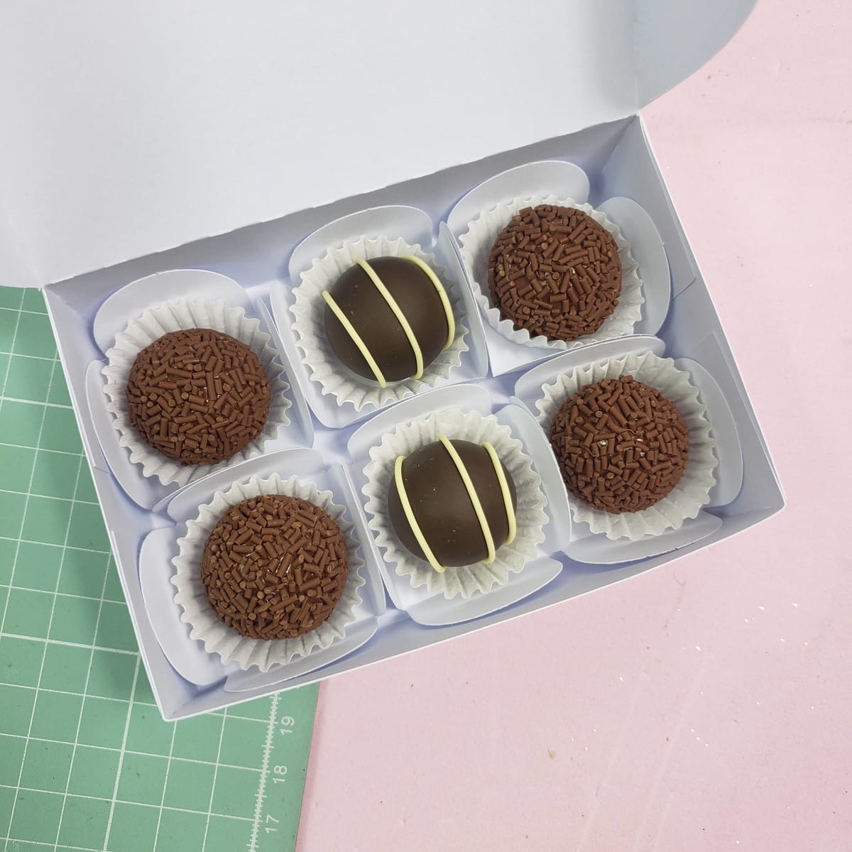 Lembrancinhas de Natal para Clientes prontas para Imprimir 4 Caixa branca contendo seis doces de chocolate decorados com granulado e riscas.