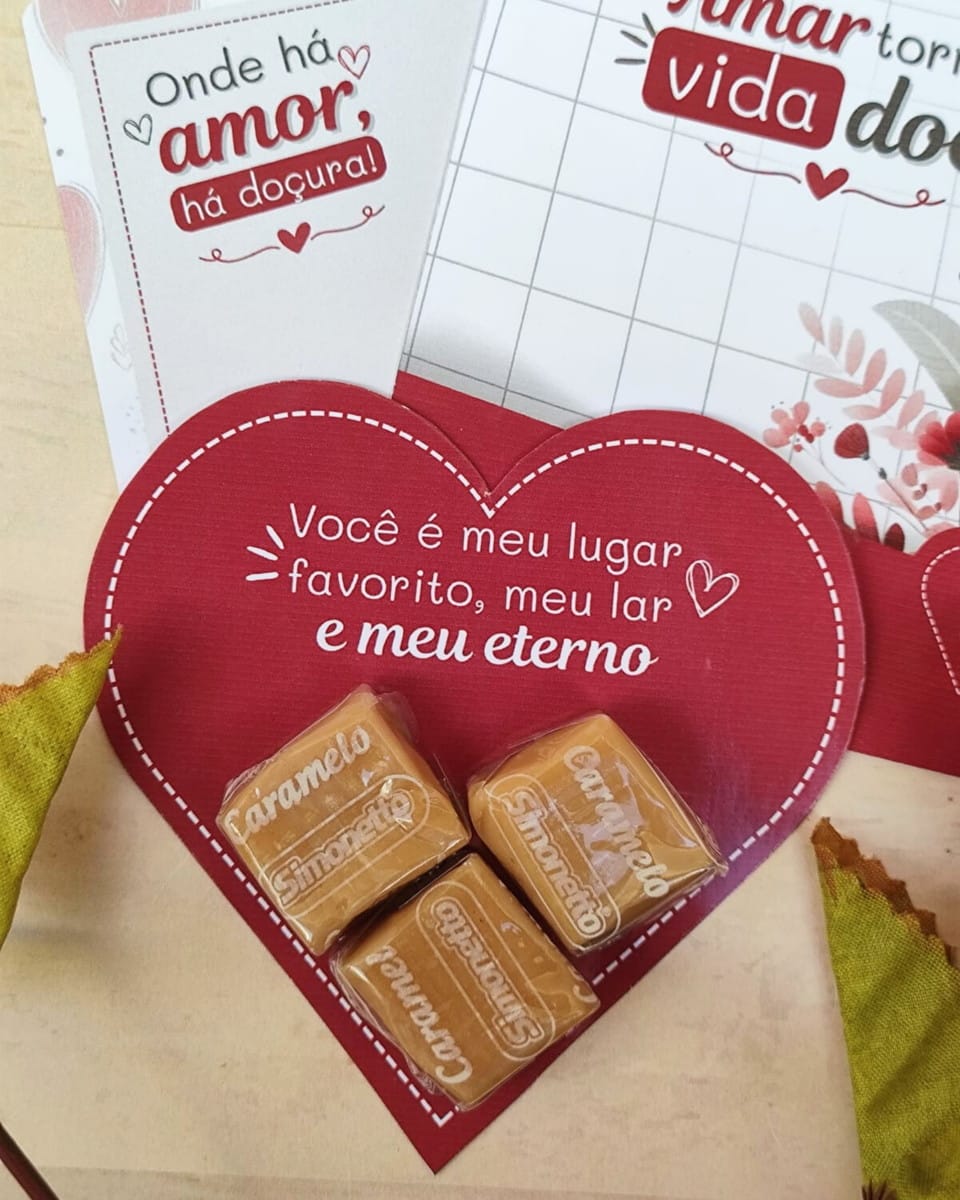 Kit Digital Mimos Casal Cristão Editável no Canva 1 Cartão vermelho em formato de coração com doces de caramelo e mensagens românticas.