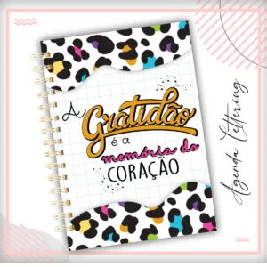 Capa de caderno com estampa de oncinha colorida e frase motivacional escrita.