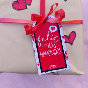 Um presente embrulhado com papel dourado, laço vermelho e tag "Feliz Dia dos Namorados".